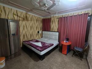 a small bedroom with a bed and a table at Hotel O Gongma Guest House in Leh