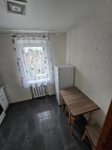 a small kitchen with a table and a refrigerator at 1 кімнатна квартира в центрі міста in Sumy