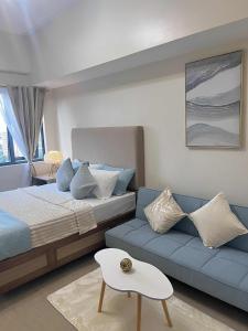 Un dormitorio con una cama y un sofá azul. en ABE Place, en Cebú 6 fotos más