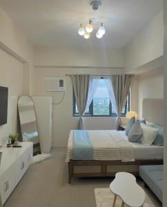 Un dormitorio con una cama grande y una ventana en ABE Place, en Cebú