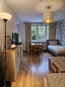 a living room with a couch and a table at Justinrent Piekarska in Legnica
