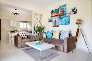 a living room with a couch and a table at Rehano by Leo Homes - 2BHK Flat near Anjuna Beach in Anjuna