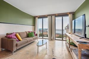 un soggiorno con un divano e una grande finestra di Maison Lacroix - Duplex a Sète