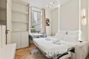 a white bedroom with a bed in a room at Charming Levallois-Perret studio near Paris in Levallois-Perret