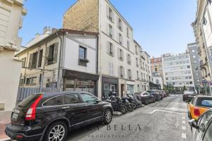 a black car parked on the side of a city street at Charming Levallois-Perret studio near Paris in Levallois-Perret