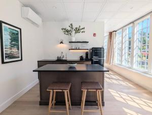 Una cocina con una gran isla con dos taburetes. en The Optimist Guesthouse | 1, en Camden 10 fotos más