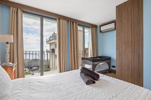 una camera da letto con un letto e un balcone con una scrivania di Maison Lacroix - Duplex a Sète Altre 29 foto