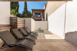 una fila di panchine su un patio con piscina di Maison Lacroix - Duplex a Sète