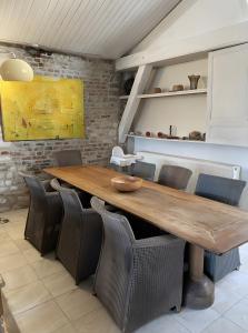 a dining room with a wooden table and chairs at Loft Hangar À Bateaux in Saint-Valery-sur-Somme
