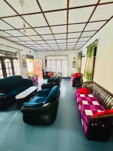 Una gran sala de estar con sofás y mesas. en Aurora Villa, en Ratgama Hegoda