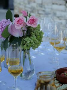 a vase filled with pink roses on a table with wine glasses at Hani i Qerosit in Kuçovë