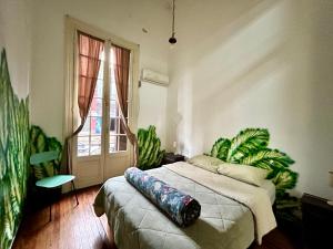 a bedroom with a bed and a large window at Hostel Bohemian in Montevideo