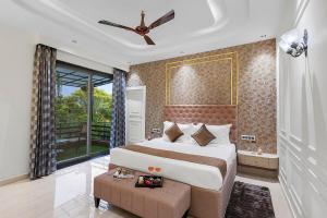 a bedroom with a large bed and a ceiling fan at Shreya Blossom Retreat 4-BHK Retreat With Private Pool, Gazebo, Garden, Bar & Scenic Aravali Views in Thūr