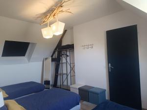 a bedroom with two beds and a ladder and a door at Le Chant des Vagues in Audinghen