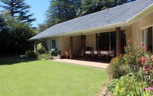 a house with a table and chairs in a yard at Hawley House in Underberg