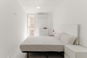 ein weißes Schlafzimmer mit einem Bett und einem Fenster in der Unterkunft LC Apartaments Centro Plaza la Paz in Castellón de la Plana