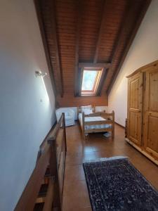 Una sala de estar con techo de madera con una ventana. en The elf's house, en Tarvisio