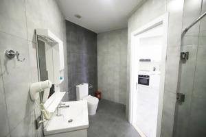 Un baño con un lavabo blanco y un inodoro. en Vitrage Hotel, en Baku