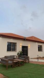 a building with benches and a table in the grass at جمعتنا in Al Qā‘id