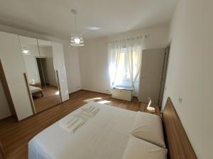 a white bedroom with a bed and a mirror at Don Bosco Holiday Home in Rome