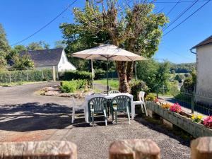 Una mesa y sillas bajo una sombrilla en una carretera. en La Maison Marguerite, en Herrère