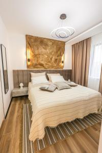 a bedroom with a large bed with a large headboard at Apartment Cocosinella in Surčin
