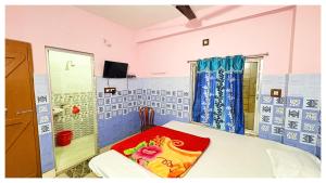 ディガにあるরাধেশ্যাম হোটেল এন্ড রেস্টুরেন্ট Radheshyaam Near Sea Beachの青と白のタイル張りの壁、ベッド1台が備わるベッドルーム1室