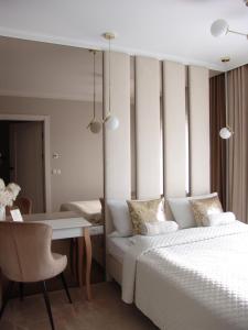 a bedroom with a bed and a table and a desk at Apartment LUXOR - Airport Katowice-Pyrzowice in Bobrowniki