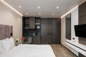 a bedroom with a white bed and a television at Status Apartments in Kyiv
