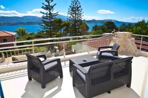 a balcony with a table and chairs and a view of the water at Diwani Luxury Villas in Lixouri