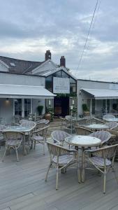 a group of tables and chairs in front of a building at Old Store Cottage, Up Holland in Upholland