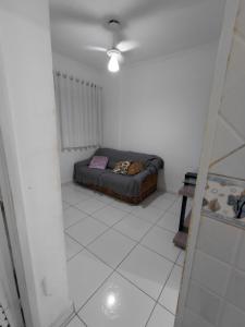 una sala de estar con sofá en una habitación blanca en Apartamento Mirim, en Praia Grande