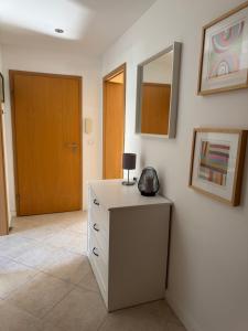 Cette chambre comprend une commode avec un miroir et une porte. dans l'établissement Nest,Ruhe und Erholung, à Castrop-Rauxel