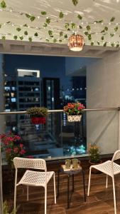 d'un balcon avec deux chaises, une table et une fenêtre. dans l'établissement Casa Bloom - 2 BHK - Balewadi - Family Only, à Pune