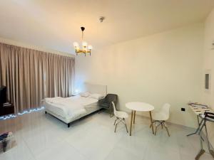 a bedroom with a bed and a table and chairs at Mahenti - Lawnz · Well furnished apt with balcony in Dubai