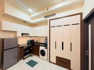 a kitchen with white cabinets and a washer and dryer at Mahenti - Lawnz · Well furnished apt with balcony in Dubai