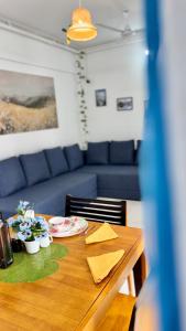 une table à manger avec un canapé bleu dans l'établissement Casa Bloom - 2 BHK - Balewadi - Family Only, à Pune