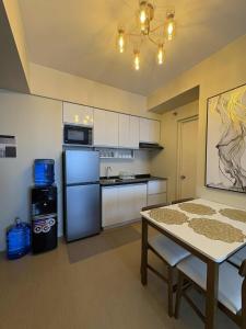a small kitchen with a table and a refrigerator at A Cozy and Spacious Condo in the Heart of Downtown in Cagayan de Oro