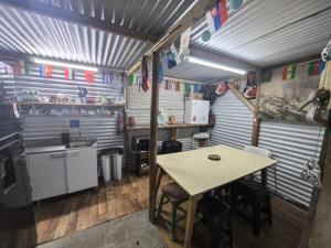 a kitchen with a wooden table and a table and chairs at Alojamiento Emilia House y camping in Punta Arenas