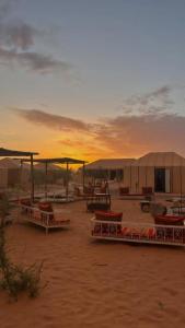 grupa namiotów na pustyni o zachodzie słońca w obiekcie Desert luxury w mieście Merzouga