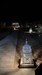 klatka dla ptaków stojąca na środku drogi nocą w obiekcie Desert luxury w mieście Merzouga
