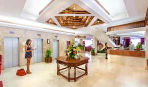 a woman standing in the lobby of a hotel at Apartamentos Masaru in Puerto de la Cruz