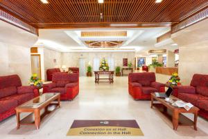 a lobby of a hospital with red couches and tables at Apartamentos Masaru in Puerto de la Cruz
