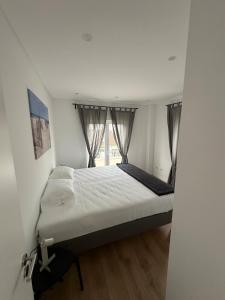 a small bedroom with a bed with a window at Solar da Sobreda in Sobreda
