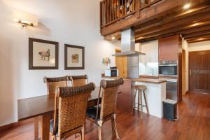 Una cocina con una mesa y sillas de madera. en Casa Independiente En Angoustrine, en Angoustrine