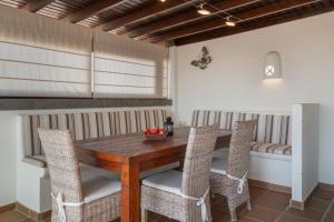 a dining room with a wooden table and chairs at Villa Los Alisios 58 in Playa Blanca