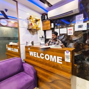 a man sitting at a welcome counter in a store at Hotel Aashray Residency Lodging And Boarding in Jāmb