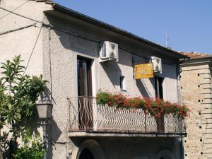 a building with a balcony with flowers on it at B&B Mamma Elena in Rovito