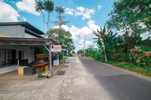 Une rue vide à côté d'un bâtiment arboré dans l'établissement Halona Taraman Guest House by Yurooms, à Ngemplak