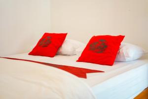 - un lit avec 2 oreillers rouges dans l'établissement Halona Taraman Guest House by Yurooms, à Ngemplak